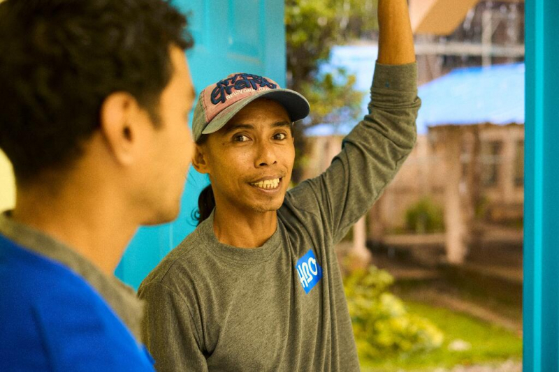 Techitong speaks to one of the construction workers building shelters.