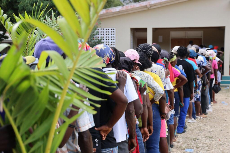 People displaced by violence in Haiti wait in line at an aid distribution site.